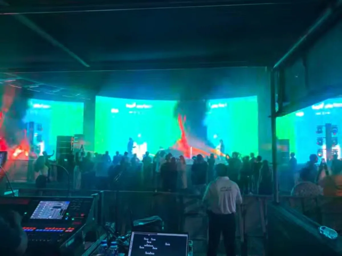 View from the visuals booth of a lit stage and LED wall