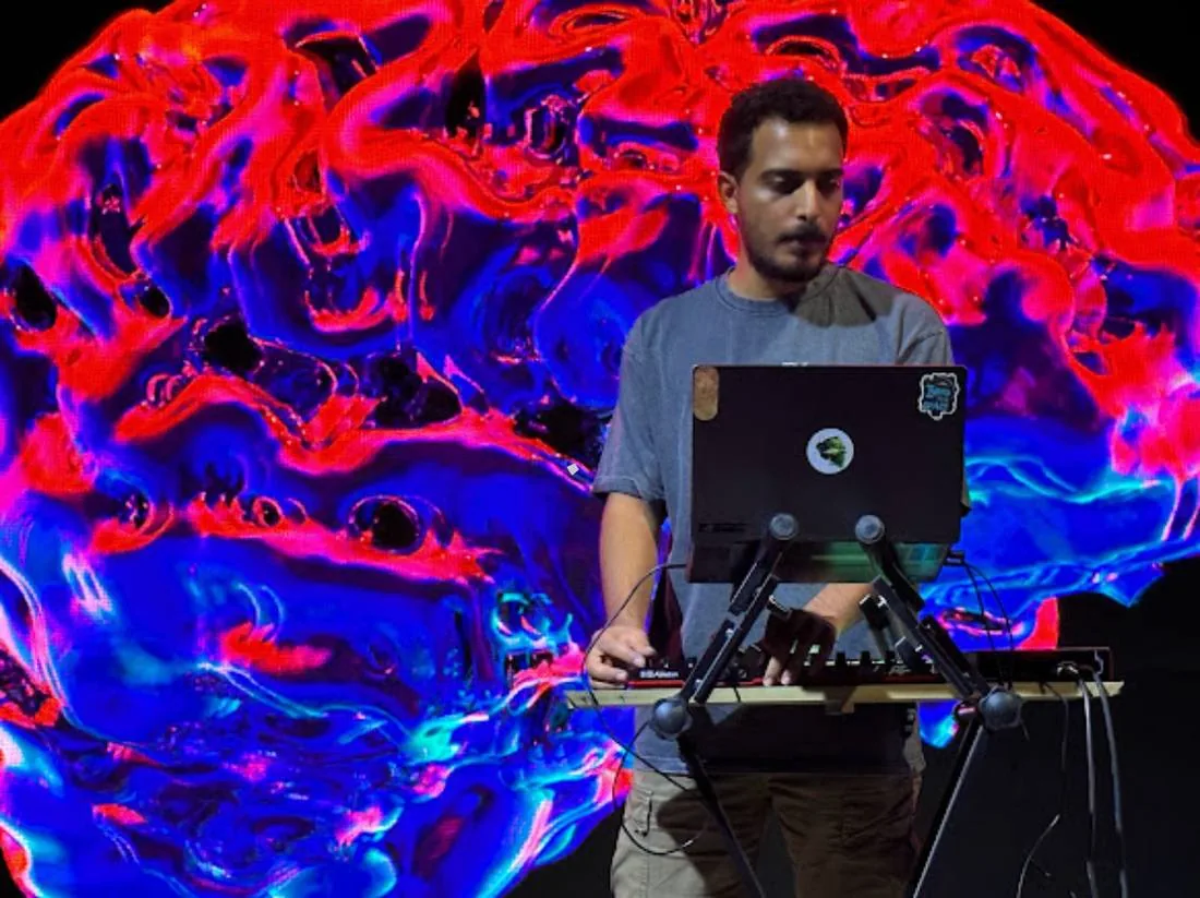El Waili performing against a red and blue projection
